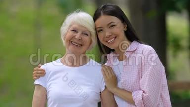年轻女子带着<strong>年迈</strong>的祖母对着镜头微笑，在户外放松